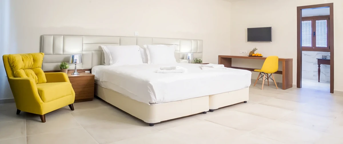 Suite δωματίου στο Hotel Electra στον Σταυρό Θεσσαλονίκης με κίτρινη πολυθρόνα