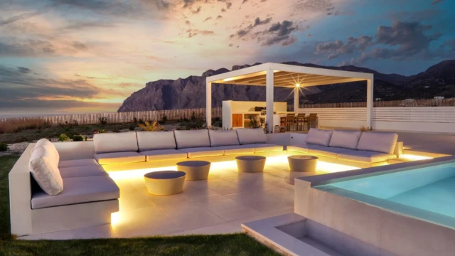 Outdoor lounge area with pool at a luxury tourist villa in Crete Υπαίθριο lounge πολυτελούς τουριστικής βίλας στην Κρήτη με πισίνα και ατμοσφαιρικό φωτισμό στο ηλιοβασίλεμα