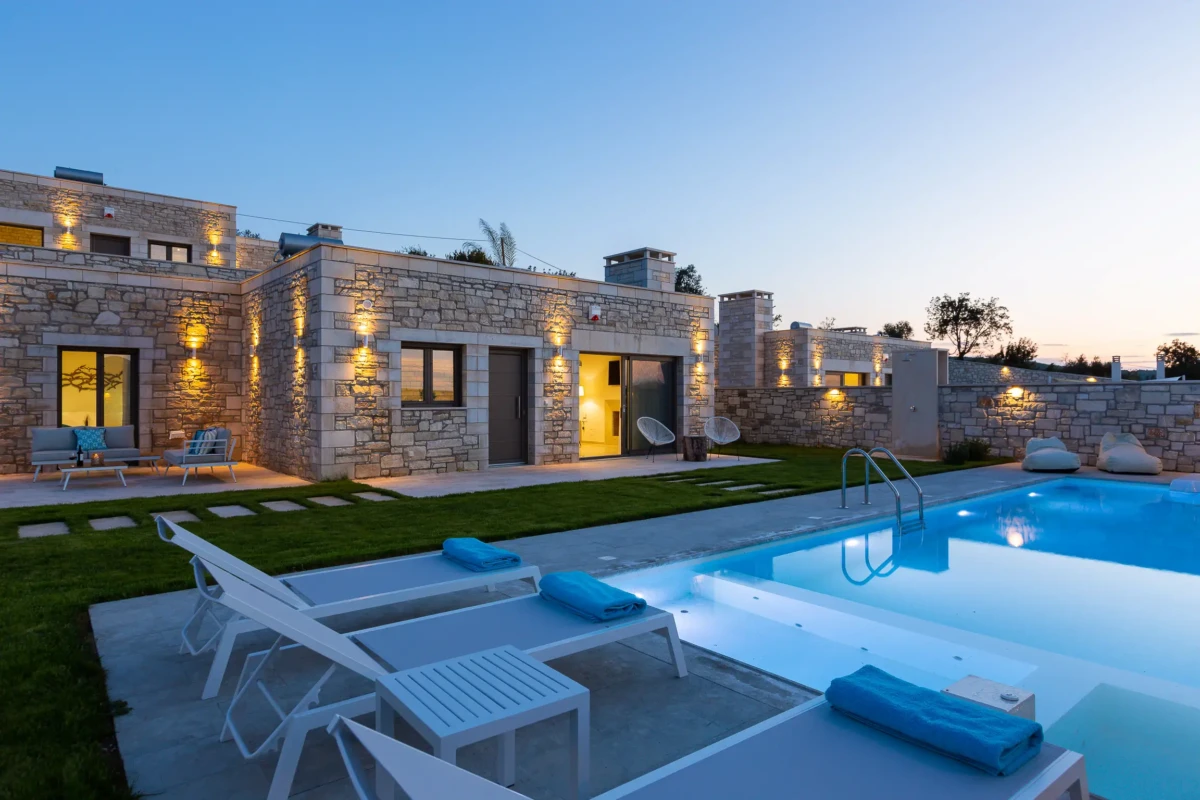 luxury villas Βραδινή άποψη πολυτελών πέτρινων τουριστικών βιλών στην Κρήτη με πισίνα και αρχιτεκτονικό φωτισμό